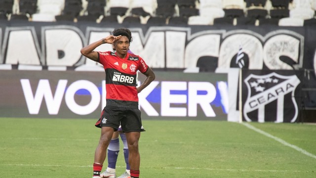 Menino Do Jogador De Futebol Que Pisa Na Bola Na Sala Imagem de